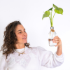 אישה מחזיקה בקבוק עם צמח הידרופוני